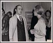Wilder Penfield of the Toronto Sun talking with  Liona Boyd, classical guitarist, at a reception [ca 1970]