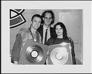 Portrait of Pat Benatar and Neil Giraldo after their show at the Montréal Forum where they were presented platinum awards for their album Wide Awake in Dreamland. The Award was presented by Chrysalis Label Manager Cameron Carpenter [ca. 1988].