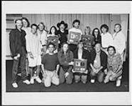 Portrait de groupe du personnel du siège social de BMG Music Canada et du bureau de l'Ontario en compagnie de Kix Brooks et de Ronnie Dunn, lors de la présentation de disques platines pour souligner les ventes de plus de 100 000 exemplaires chacun du premier disque du duo, Brand New Man et de son deuxième disque sous l'étiquette BMG/Arista, Hard Workin' Man. En coulisses au CNE de Toronto [ca 1992]