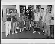 Portrait de membres de Bon Jovi qui tiennent leur disque double platine pour l'album These Days et leur disque septuple platine pour l'album Cross Road: The Best Of Bon Jovi. Les prix ont été remis aux membres du groupe par des membres du personnel de PolyGram à Toronto September 3, 1995