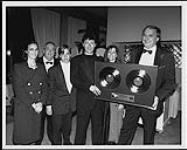 Robbie Robertson celebrated with his family and WEA staffers after winning several Junos for his solo work and being inducted into The Hall of Fame [ca 1989].