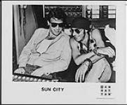 Publicity portrait of Sun City sitting in a recording studio 1985