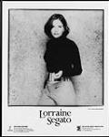 Photo publicitaire de Lorraine Segato debout appuyée contre un mur [ca 1997].