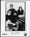 Publicity portrait of Sloan posed with an organ, recording instruments and a guitar April, 1996