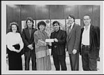 Christine Hart (Ontario Culture and Communications Minister) presenting Eddie Schwartz (Vice President, Songwriters Association of Canada) with a cheque for the promotion of Canadian artists at New Music Seminar 11 in New York - (left to right) Donna Murphy (SAC), Graham Stairs (Intrepid Records), Christine Hart, Eddie Schwartz (SAC), Stephen Stohn (SAC), Stuart Raven-Hill (Intrepid Records) 1989.