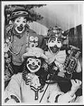 The Sphere Clown Band dressed in clown costume and holding musical instruments [entre 1983-1994].