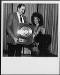 Sheila E receiving a Gold album award for 'The Glamorous Life' from Stan Kulin (WEA President) 1984.
