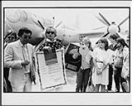 Rod Stewart posing in front of an airplane, being given the 'keys to the city' and a proclamation for 'Rod Stewart Day,' Vancouver, British Columbia July 10, 1984