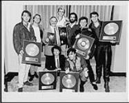 Spandau Ballet receiving Platinum and Gold awards for "True" - (left to right, back row) Martin Kemp, Steven Dagger (Manager), Ross Reynolds (Ex. VP and Sr. GM, MCA Records Canada), Steve Norman, Steven Tennant (Marketing Manager, Chrysalis Records), Gary Kemp, Tony Hadley, (front row) Lesley Soldat (National Promo Manager, MCA Records), John Keeble [ca 1983].