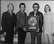 Conway Twitty holding an album award - (left to right) Barry Nesbitt, Conway Twitty, Scott Richards, Jack Winter [entre 1970-1975].