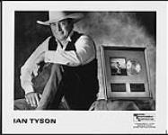 Publicity portrait of Ian Tyson sitting next to an album award [ca. 1989].