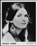 Publicity portrait of Sylvia Tyson wearing earrings made of peacock feathers [between 1975-1980].