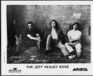 Press portrait of the Jeff Healey Band sitting in grass against a wall [between 1989-1993].
