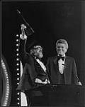 Ronnie Hawkins holding up a Juno Award, standing beside Tommy Hunter [ca 1982].