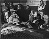 Un groupe de personnes assises dans un studio d'enregistrement [between 1970-1979].