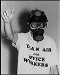 Unidentified man wearing gas mask and golf shirt that reads "Clean air for office workers" (possibly Ben Kerr) [entre 1985-1995].