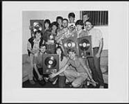 Attic Records presents gold awards for "Walking On Sunshine" (the 45) and "Katrina and The Waves" (the group's 3rd Canadian lp) to Katrina and The Waves backstage at Kingswood Music Theatre. Pictured with the group are: Ralph Alfonso, Velma Buckley, Al Mair and Lindsay Gillespie (Attic) ; Pat Ryan, Ray Rosenberg & Coralee Hummel (A&M) ; Mike White (Trick or Treat Booking) ; The Waves are: Katrina [entre 1983-1985].