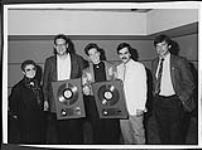 K.D. Lang with a Gold Record for "Shadowland," Toronto. Pictured left to right are: Jo Bergman, Warner Bros. Vice-President Video, Larry Wanagas (k.d.'s manager), k.d. lang, Randy Sharrard, Ontario Promotion and Dave Tollington, Domestic Production Manager [entre 1988-1989].