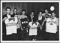 Huey Lewis and the News holding Whitecaps jerseys and an award for their album Sports [entre 1984-1986]