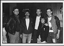 Huey Lewis posing with an unidentified group [between 1984-1986]