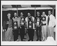 The Mavericks receive platinum for their "Music For All Occasions" CD at their June Kingswood show. Pictured from left to right are Ross Reynolds (MCA President), Nick Kane, Robert Reynolds, Raul Malo, Paul Deakin, Jerry Dale McFadden and Stephen Tennant (MCA V.P. Marketing) [between 1995-1996].