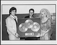 Dolly Parton recevant un triple Platine pour « Once Upon A Christmas » de Kenny et Dolly [ca. 1984].