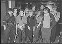 Dernier ajout à l'équipe du matin à CHOM, Terry diMonte, photographié avec des membres de Parachute Club en coulisse après leur plus récent spectacle à Montréal [between 1983-1987].