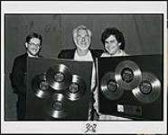 Membres de RCA/Ariola International Canada présentant Kenny Rogers avec un quadruple Platine pour « Eyes That See In The Dark », et triple Platine pour la chanson « Once Upon A Christmas » de Kenny et Dolly [entre 1983-1984].