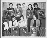 Capitol Records recording group The Motels receiving their Gold Award for their album "Little Robbers". Top row, left to right: Scott Thurston, Martha Davis, Dave Evans (president of Capitol Records Canada), Marty Jourard, Guy Perry. Bottom row, left to right: David Platshow, Brian Glascock, and Michael Goodroe [between 1983-1985]