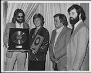 Anne Murray receiving a gold album (Australia) and gold single (New Zealand) award at the Aladdin Hotel, Las Vegas. From left to right: Bruce Portman (International Promotion Manager), Anne Murray, Don Zimmerman (President and Chief Operating Officer, Capitol-EMI Records), Ruper Perry (Vice President, Artists and Relations) [between 1978-1988]