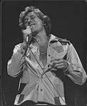 Bruce Murray qui tient un micro [entre 1976-1979].