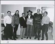 Neal McCoy presented with a gold record for his album No Doubt About It. Pictured from left to right are: Herb Forgie (Warner), Les Martinez (Road Manager), Garry Newman (Warner), Neal McCoy, Stan Kulin and Doug Raaflaub (Warner) [ca. 1994].