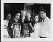 Steve Cranwell (droite), vice-président du marketing chez Mercury et Polydor Canada, remet à Pauly Fuemana (alias OMC, deuxième à partir de la gauche) et à des cadres supérieurs de Polydor Australia des disques d'or pour le premier album d'OMC How Bizarre en Australie n.d.
