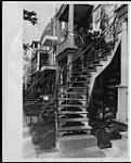 Mode et tourisme, Montréal : homme et femme sur un escalier en colimaçon [between 1950-1969]
