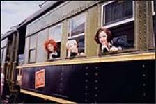 Country music trio, Farmer's Daughter, looking out the windows of a train [between 1993-2000].