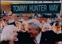 Country artist Tommy Hunter holding a street sign that reads "Tommy Hunter Way", London, Ontario [entre 1997-1999].