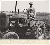 Alex Wilson Lazore, photographié en compagnie de son plus jeune fils, est un producteur agricole prospère de la réserve de Saint-Régis [entre 1930-1960]