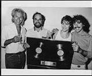 L'étoile du disque d'A&M Bryan Adams, qui a reçu des prix or et platine pour son album « Cuts Like a Knife », célèbre en compagnie de membres de l'équipe d'A&M 1983