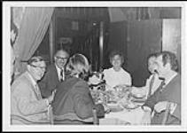 Fraser Jamieson, Ed Poggetto, Alice Koury, Alain Guillemette and Jacques Darielle eating at a dinner table [entre 1970-1975].
