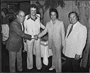 Sam Sniderman and Danny Wu, founders of Sam The Chinese Food Man, congratulate Cooley's owners, Gene Lew and Murray Campbell [between 1978-1985].