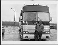 Larry Macrae de BMG près d'un autocar [entre 1996-2000].