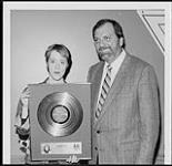 A&M Senior Vice President, Joe Summers presents Suzanne Vega with her first gold disc for "Solitude Standing" [ca. 1987].