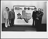Garry Barker (Promotion Director, CFRA), Ken Grant, (morning radio host, CFRA), and two Ottawa MP's stand in front of a painted sign from KHEY, El Paso, Texas [ca. 1980].