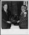 Fred W. Arenburg, Manager of CKDH Radio, accepts the John J. Gillin Station of the Year Award from Don H. Hartford avril 1975