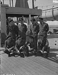 RCAF officers from Alberta aboard SS Stratheden as it docked in Quebec: Front Row, left to right, F/L D.W. Schmidt, DFC and Bar, Wetaskiwin; F/O H.E. Patch, DFM, Vegreville; F/L G.A. Berry, DFC, Lloydminster; F/O J. Perry, Lethbridge; Back Row, left to right, F/L J.M. Calder, DFC, Edmonton; F/L G.L. Scott, DFC, Innisfail; F/O G.P. Bodard, DFC, Edmonton; F/L E.S. Dunn, DFC, Calgary and formerly of Medicine Hat 13 July 1945.
