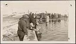 [Diver working to repair intake of water supply system at Saint John's Indian Residential School. A group of students gather to watch, Chapleau, Ontario, week of October 23, 1933] 23-29 octobre 1933