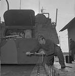 Exercise Reforger IV. Cpl. Ivey changes tread on a A.P.C. Lahr 20-24 January 1973.