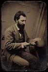 Studio portrait of Louis Riel seated at desk ca. 1875.