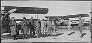 Lt C.M. McEwen (second from left) poses beside his Sopwith Camel with group 1917-1918.
