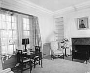 The library in the south east corner of 24 Sussex Drive, official home of Canadian Prime Ministers. The room, panelled in Canadian white pine, contains a large green marble fireplace, retained from the original house Apr. 1951